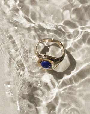 Gold stone set ring with lapis in centre worn by model