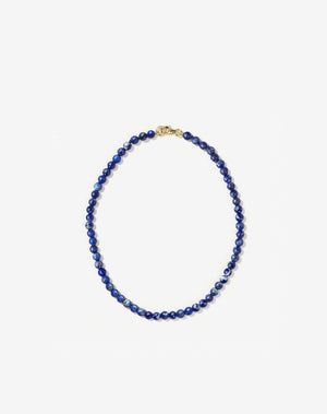 Small spherical lapis lazuli stone beads on silk thread with gold clasp anklet